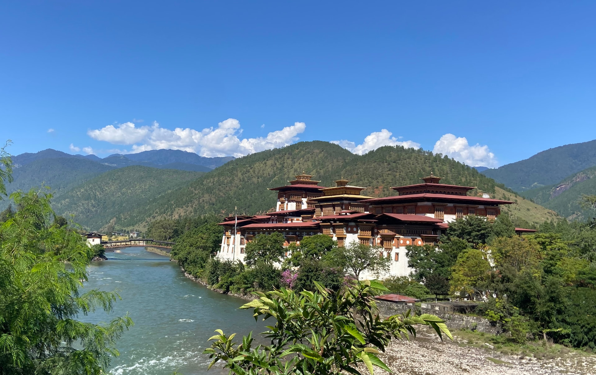 Punakha Dzong beside the river amid forested mountains in Bhutan